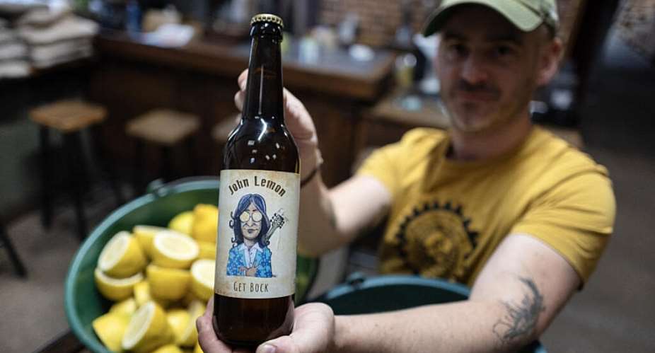 French brewer Aurelien Picard holds a bottle of a beer named John Lemon, a play on words in reference to British musician John Lennon at the brewery Brasserie de limprimerie in Bannalec, western France on 5 May 2026. - AFP - FRED TANNEAU