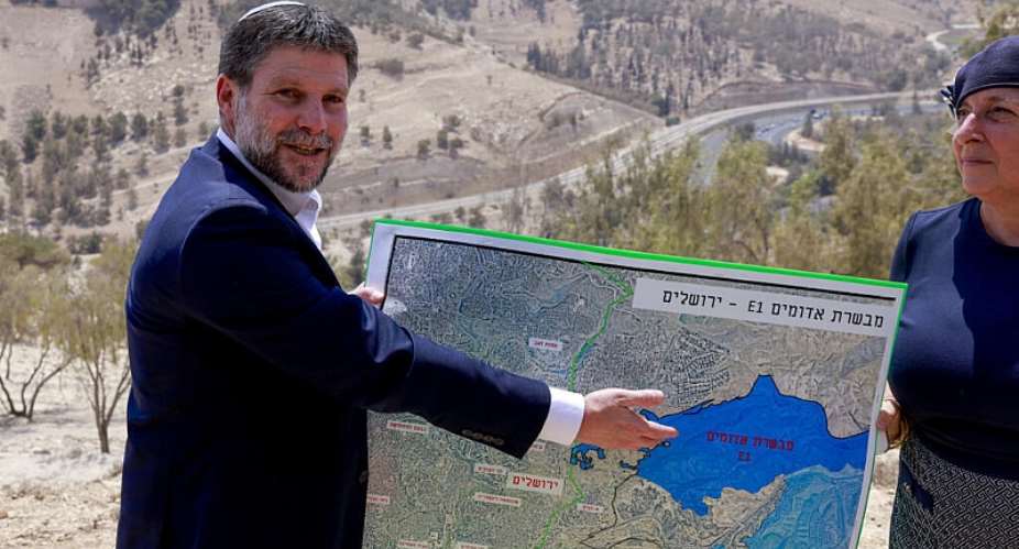 Israeli Finance Minister Bezalel Smotrich displays a map of an area near the settlement of Maale Adumim, a land corridor known as E1, outside Jerusalem in the occupied West Bank, 14 August, 2025. - AFP - MENAHEM KAHANA