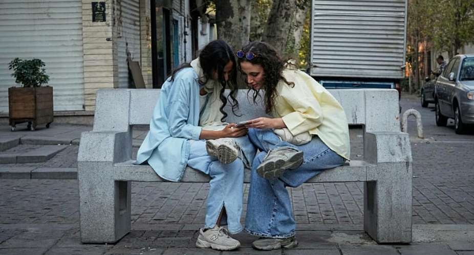 Two women use a smartphone in northern Tehran, Iran. Authorities have introduced a system that gives fuller internet access to selected users while much of the population remains under heavy restrictions. - AP - Vahid Salemi