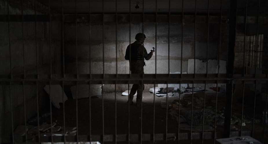 A Ukrainian serviceman stands in a basement which, according to Ukrainian authorities, was used as a torture cell during the Russian occupation, in the retaken village of Kozacha Lopan, Ukraine, Sept. 17, 2022. -  Leo Correa/AP