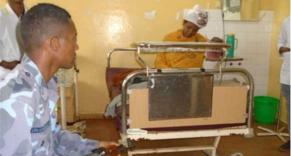 An Ethiopian woman writes exams on a hospital bed