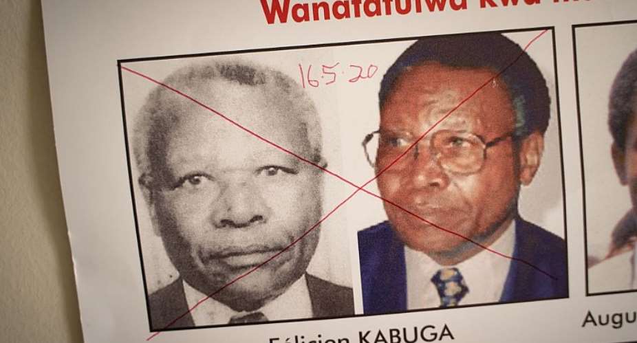 The date of arrest and a red cross marked on the face of Felicien Kabuga on a wanted poster at the Genocide Fugitive Tracking Unit office in Kigali, Rwanda, on May 19, 2020.  - Source: Photo by Simon Wohlfahrt AFP via Getty Images