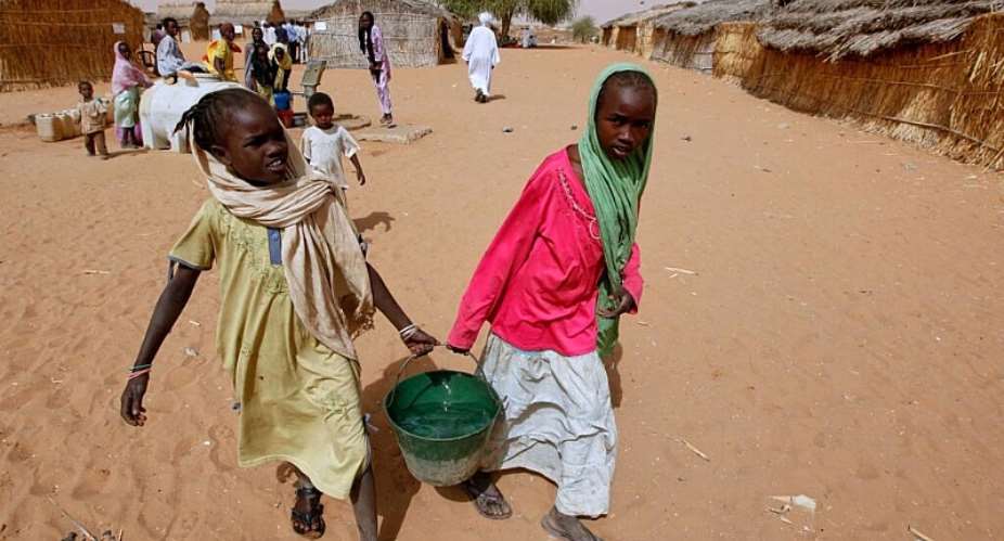 Sudanese refugees carry water supplies near a polling station in the refugee camp of Zamzam, on the outskirts of El Fasher, Darfur, in April 2010. -  AP - Nasser Nasser
