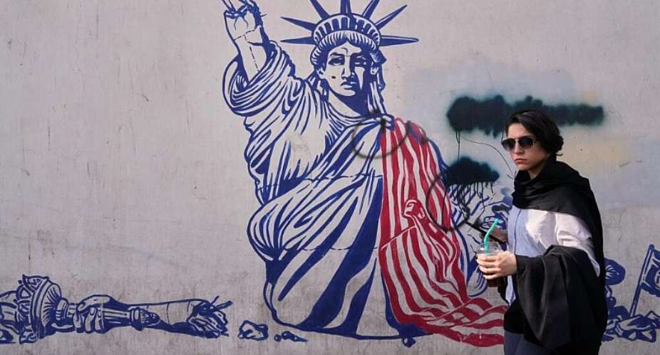 A woman walks past an anti-American mural on the wall of the former US Embassy, now a museum, in Tehran, Iran, June 12, 2026. -  Vahid Salemi, AFP