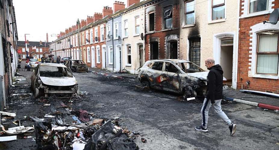 A man walks down a street after rioting broke out in east Belfast, Northern Ireland on June 10, 2026, following a stabbing incident. -  Peter Morrison, AP