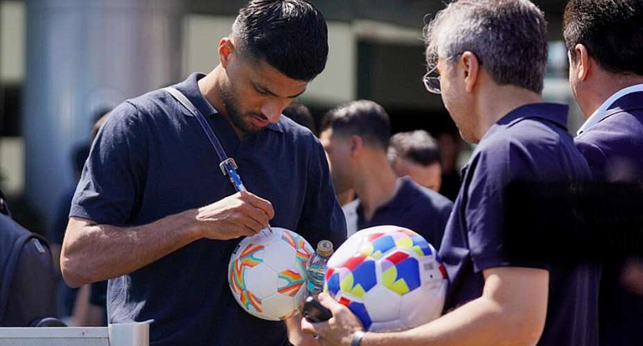 Iran’s Mohammad Mohebbi signs a football as the team leaves their hotel in Tijuana, Mexico, ahead of their first World Cup match against New Zealand. -  Victor Medina, Reuters