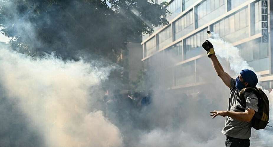 A demonstrator throws a tear gas pellet during a No-G7 protest in Geneva on June 14, 2026. -  Fabrice Coffrini, AFP