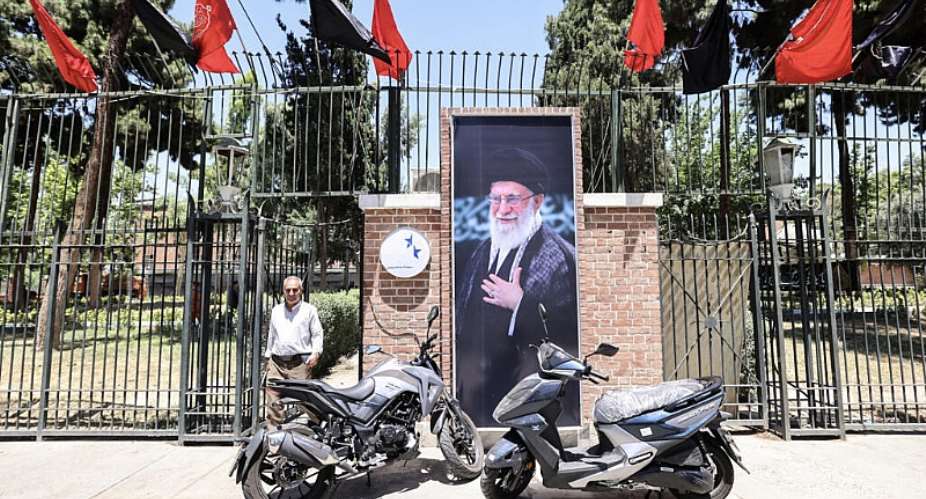 A man walks past a portrait of slain Iranian supreme leader Ayatollah Ali Khamenei near the former US embassy in Tehran on June 15, 2026. -  Atta Kenare, AFP