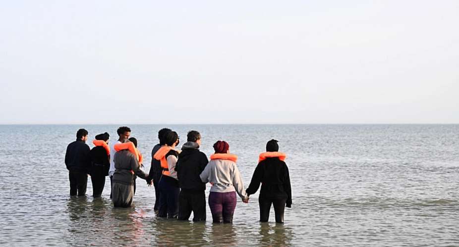 Migrants wade into the water to board an inflatable dinghy on the northern French coast near Calais before attempting to cross the English Channel to Britain, 23 May 2026. -  Dylan Martinez / Reuters