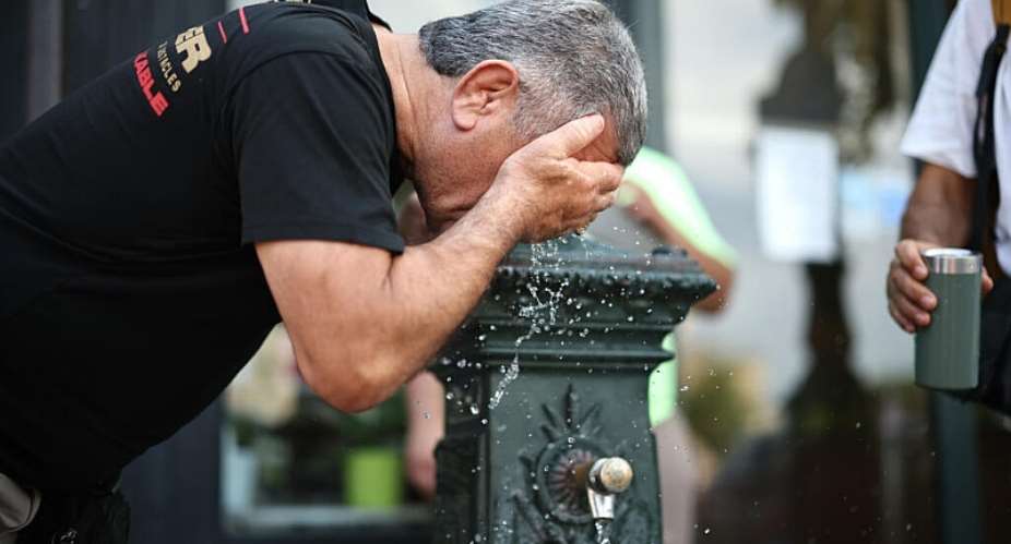 A man cools off at a public fountain in Paris on June 18, 2026. -  Simon Wohlfahrt, AFP
