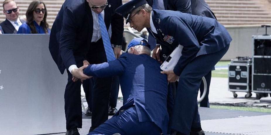 President Joe Biden being lifted by security officials after he fell