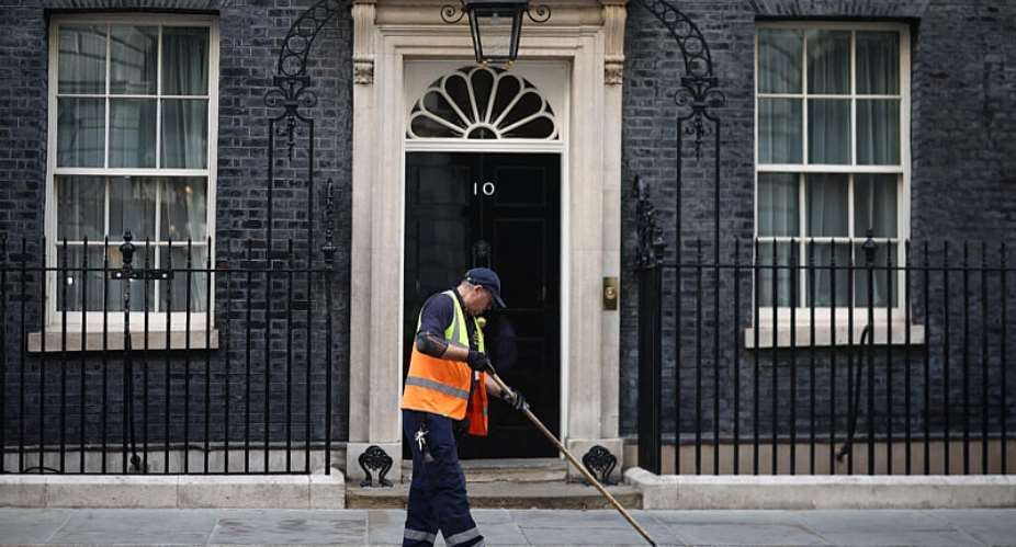 A street cleaner sweeps the gutter outside 10 Downing Street on the morning of June 22, 2026, ahead of Prime Minister Keir Starmers resignation announcement. -  Henry Nicholls, AFP