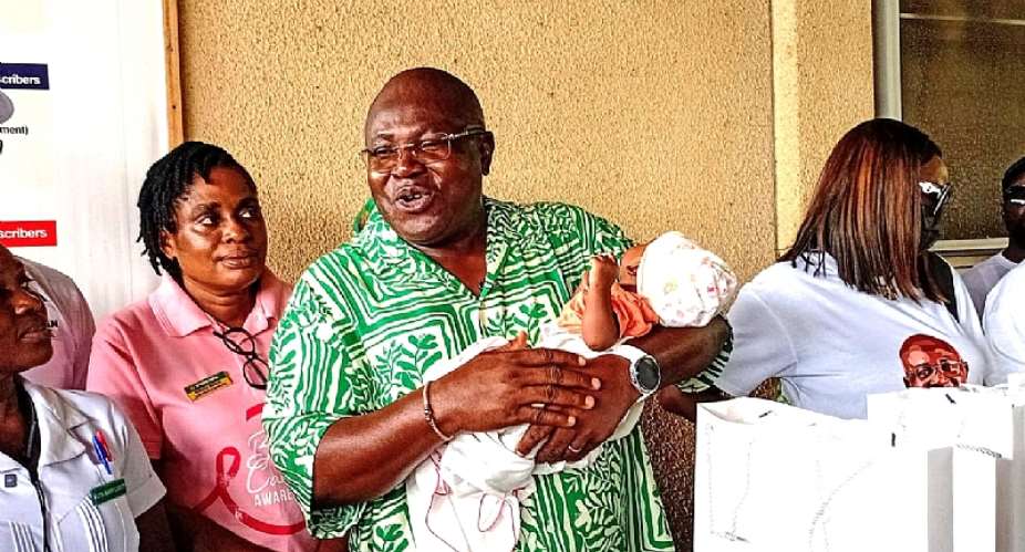 Hon. Mawutor Agbavitor, NDC Volta Regional Chairman carrying a newborn at the Ho Teaching Hospital during the donation exercise to mark his birthday.