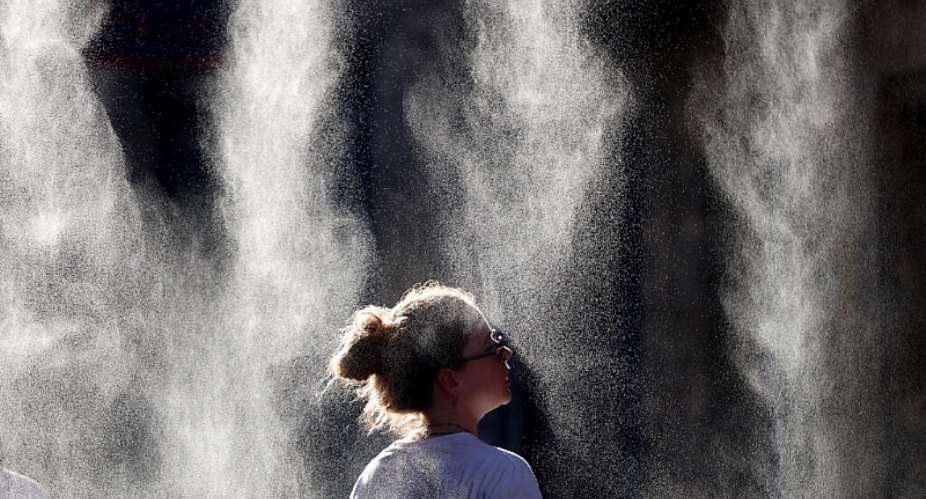A woman cools off under a mist sprayer during the Fte de la Musique festival in Bordeaux, southwestern France, on 21 June 2026. Much of France remained under heat alerts on Wednesday after the country recorded its hottest day since records began. - AFP - ROMAIN PERROCHEAU