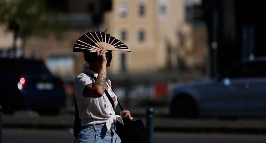A woman shields herself from the sun with a fan in the Breton city of Rennes, in western France, on June 22, 2026. -  Jeremias Gonzalez, AP