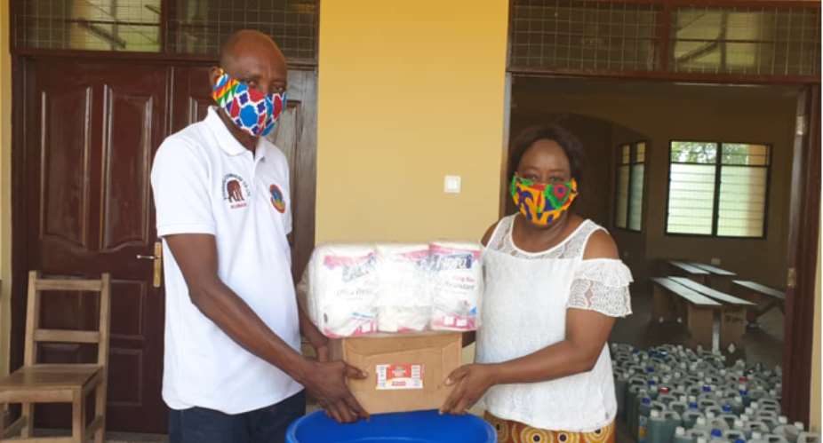 Madam Charity A.F. Dwommoh DCE Handing Over The Items To Mr. Mark Domah, Education Director