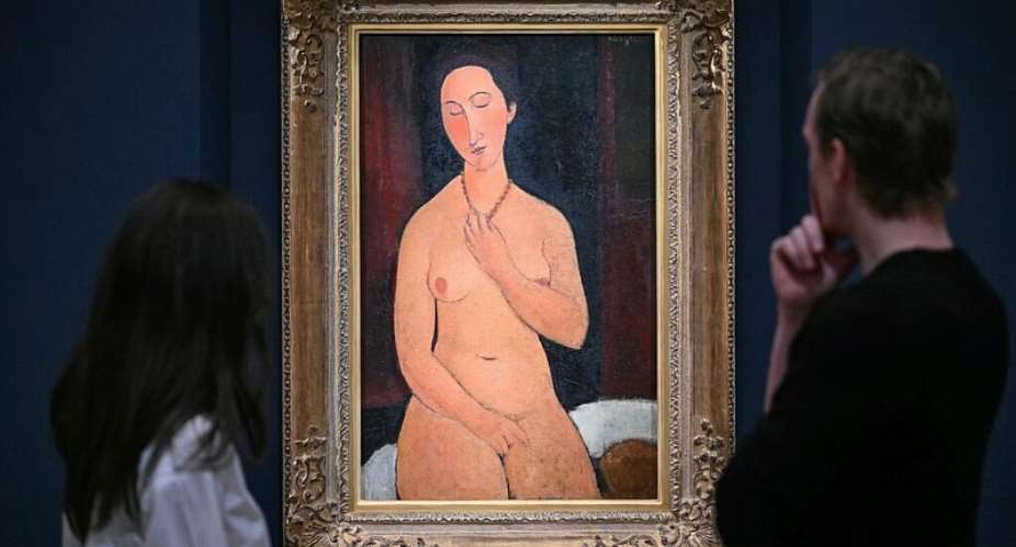 Staff members pose next to Amedeo Modigliani’s Nu assis au collier, during a media preview by Sothebys in London to highlight masterpieces from the Lewis Collection, with an initial estimate of at least 200 million pounds ($267 million) -  JUSTIN TALLIS, AFP