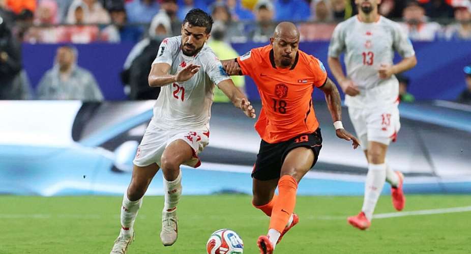 Tunisias Mohamed Amine Ben Hamida in action with Netherlands Donyell Malen. -  Siphiwe Sibeko, Reuters
