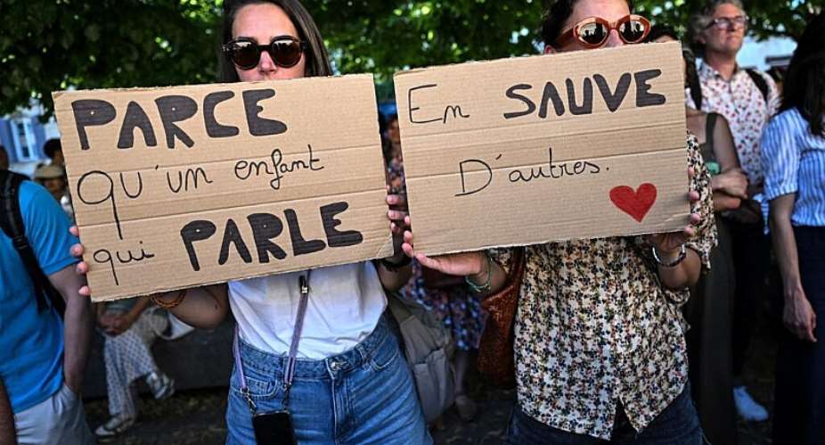 Women hold signs reading Because a child who speaks up... saves another at a protest outside the judicial court in Bordeaux, 15 June. -  Christophe Archambault/AFP