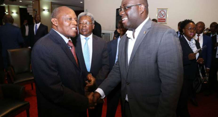 Sammi Awuku in a warm handshake with Justice Atugu with Justice Appau looking on