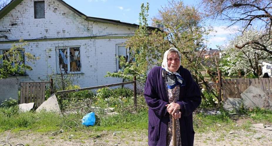 An elderly woman near her damaged home in Chernihiv Region. Photo: IOM 2022