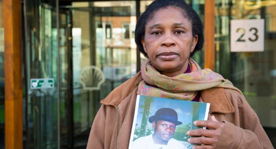 Esther Kiobel poses with a picture of her late husband, one of nine men executed by Nigerias military government after a peaceful uprising against Shell in 1995. Photograph: Amnesty International