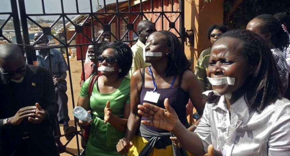Employees of the Daily Monitor newspaper with their mouths taped shut, during a protest against the closure of their premises by the Uganda government, in the capital Kampala, on 20 May, 2013. - Reuters/James Akena