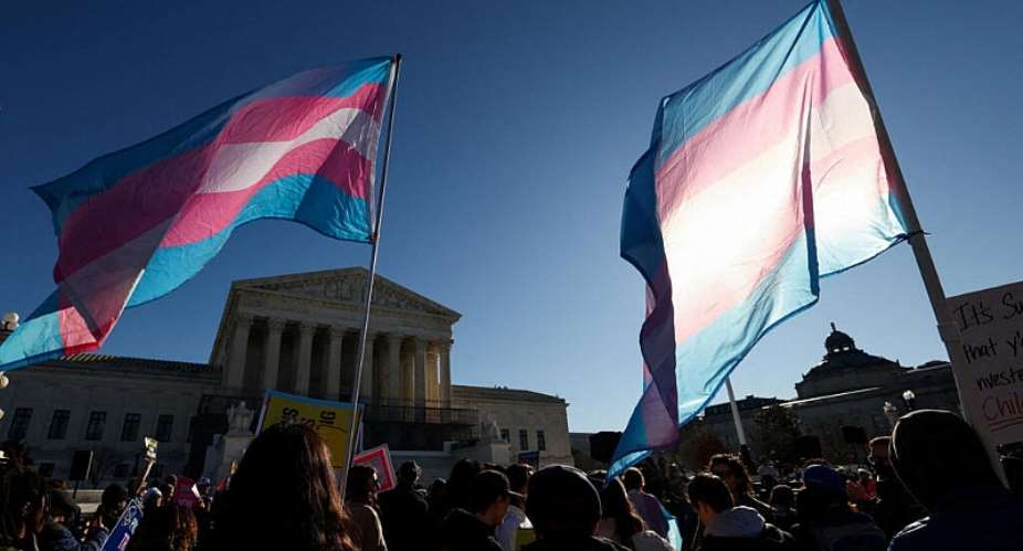 Demonstrators carry a transgender flags outside the US Supreme Court, on the day justices are expected to hear oral arguments in two cases concerning efforts to enforce Republican-backed state laws banning transgender athletes from female sports teams at public schools, in Washington, DC, US, January 13, 2026. -  Kevin Lamarque, Reuters