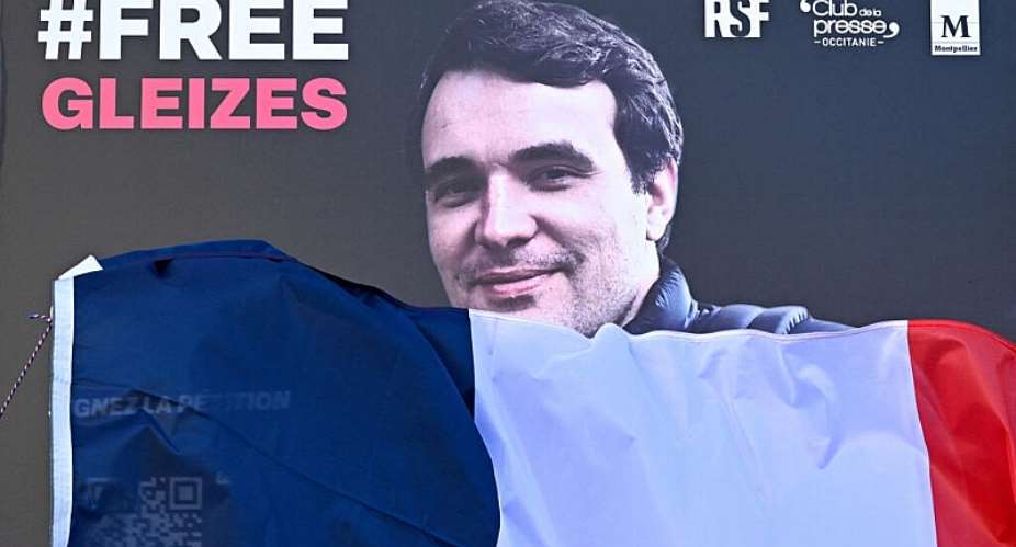 A portrait of French journalist Christophe Gleizes, who is detained in Algeria, is unveiled during a demonstration organised by the Occitanie Press Club and rights group Reporters Without Borders (RSF) to demand his release in Montpellier, southern France on January 29, 2026. -  Gabriel Bouys, AFP