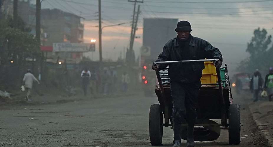 A man pulls a cart through the early morning smog in Nairobi. - Source: TOBIN JONESAFP via Getty Images