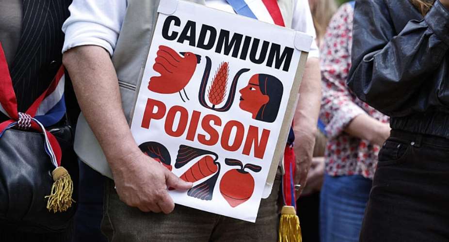 A French MP holds a placard reading cadmium, poison during a protest ahead of a debate at the National Assembly of their bill, which aims at limiting exposure to cadmium in Paris on 2 June, 2026. - AFP - SIMON WOHLFAHRT