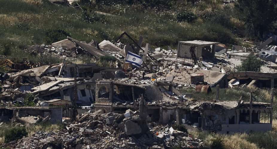 An Israeli flag is seen on top of a destroyed building in the southern Lebanese village of Kfar Kela. -  Jalaa Marey, AFP