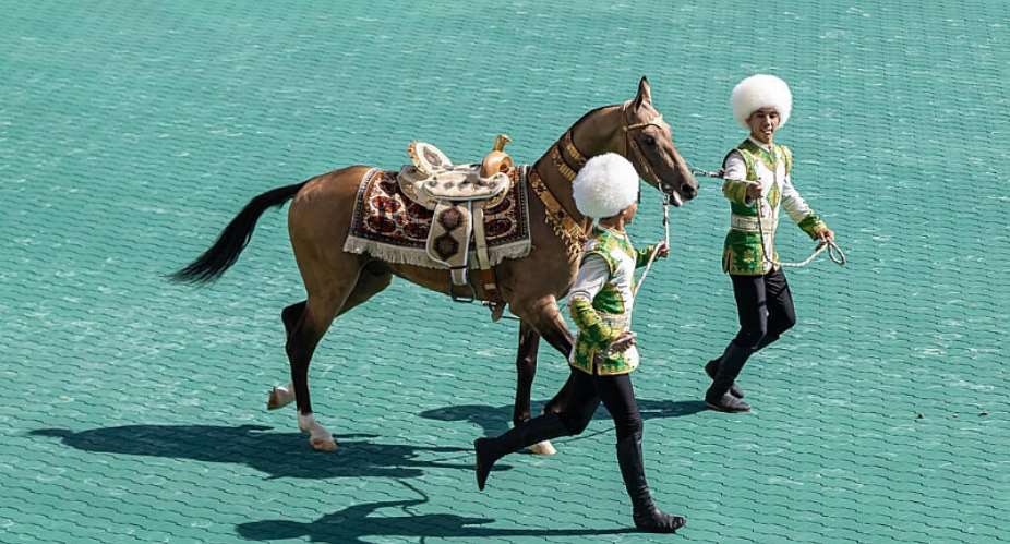 Trainers lead an Akhal-Teke stallion during its presentation at an Akhal-Teke breed beauty contest in an equestrian complex in the Turkmen capital of Ashgabat on April 25, 2026. -  AFP
