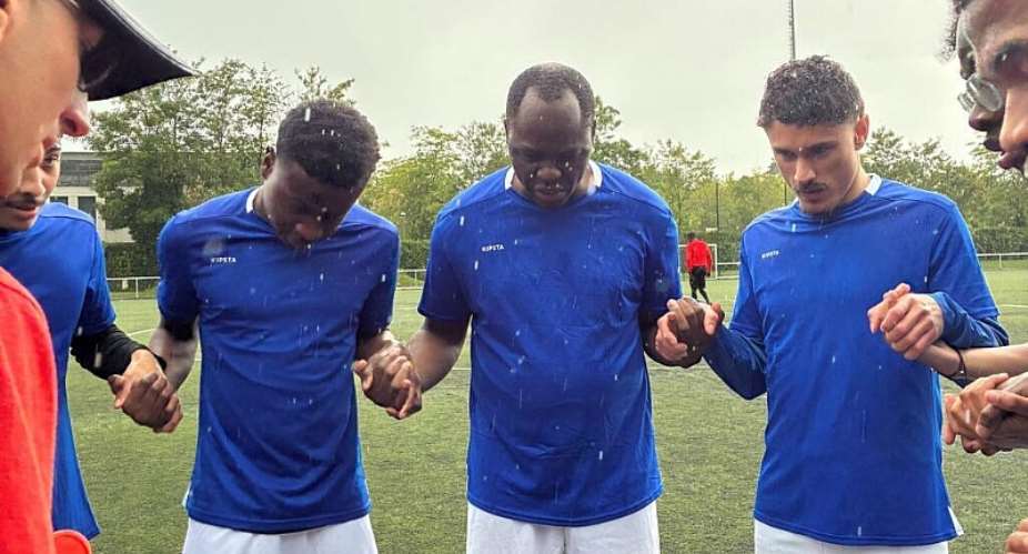 Father Jacques Noah Biko (centre) prays with members of the Saint-Georges team before a match. -  Laurence Thault/RFI