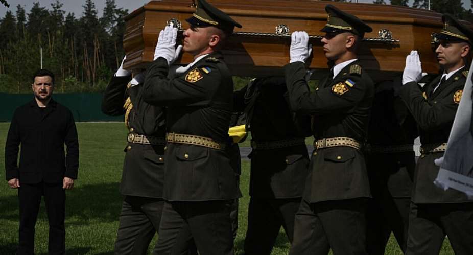 Ukraines President Volodymyr Zelensky (L) attends the reburial ceremony of Andriy Melnyk, who died in 1964 and was the leader of a branch of the Organisation of Ukrainian Nationalists (OUN), along with his wife Sofia, at the National Military Memorial Cemetery near Kyiv on May 25, 2026. -  Genya Savilov, AFP