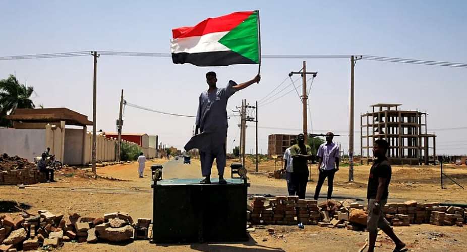 A protester in the city of Khartoum with a flag of Sudan
