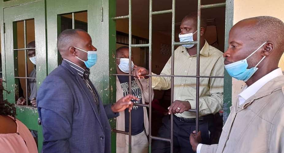 Journalists Darious Magara in jail cell, left and Pidson Kareire in jail, right are seen with Robert Ssempala left, the executive director of the Human Rights Network for Journalists-Uganda, while in detention on criminal libel charges. Photo: HRNJ-U