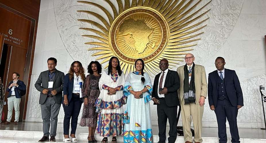 Dr. Ergogie, Minister of Women and Social Affairs, standing fourth from right, in front of the conference hall.
