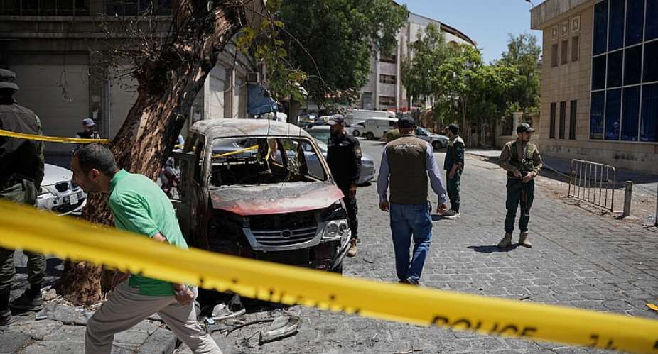 Syrian security personnel inspect a burned vehicle near the Four Seasons Hotel after two explosions rocked the area, Damascus, Syria, July 7, 2026 -  Omar Albam, AFP
