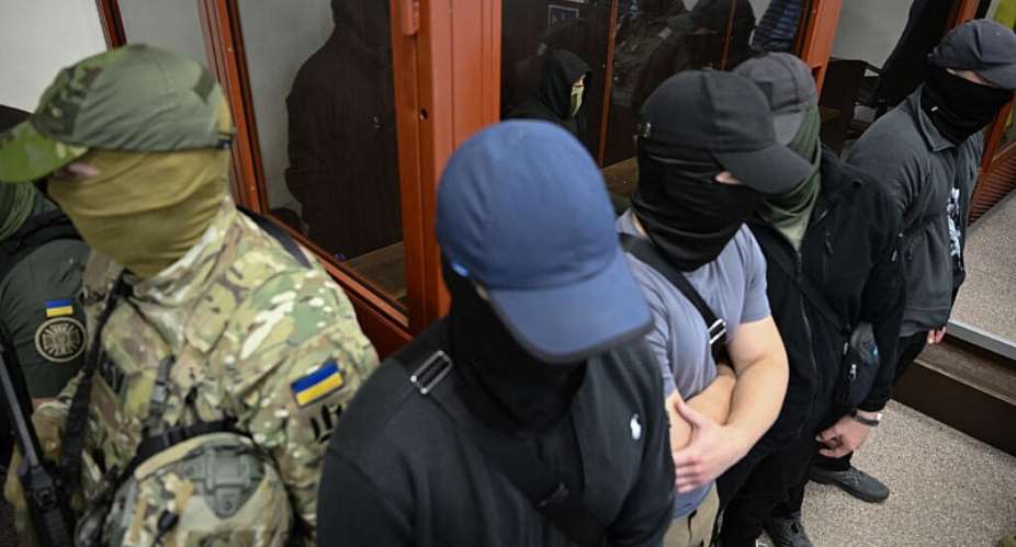 One of the suspects in the murder of a woman accused of carrying out an assassination plot in Monaco (C) sits in the dock as they attend a court hearing in Kyiv on July 9, 2026. -  Genya Savilov, AFP