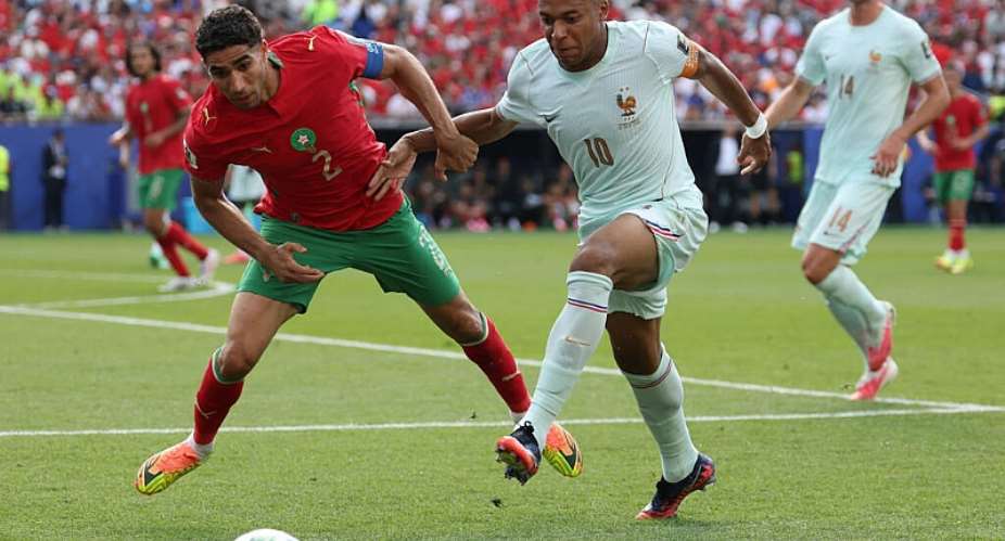 Morocco defender Achraf Hakimi (L) and France forward Kylian Mbappe fight for the ball during a World Cup quarter-final. -  Odd ANDERSEN / AFP