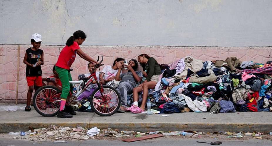 Nios que perdieron sus hogares en los terremotos descansan sobre un montn de ropa donada en una calle de La Guaira, Venezuela, el 29 de junio de 2026. -  Reuters/Gaby Oraa