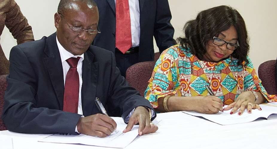 Mr. Makove and Madam LaribaBawa simultaneously signing the MoU