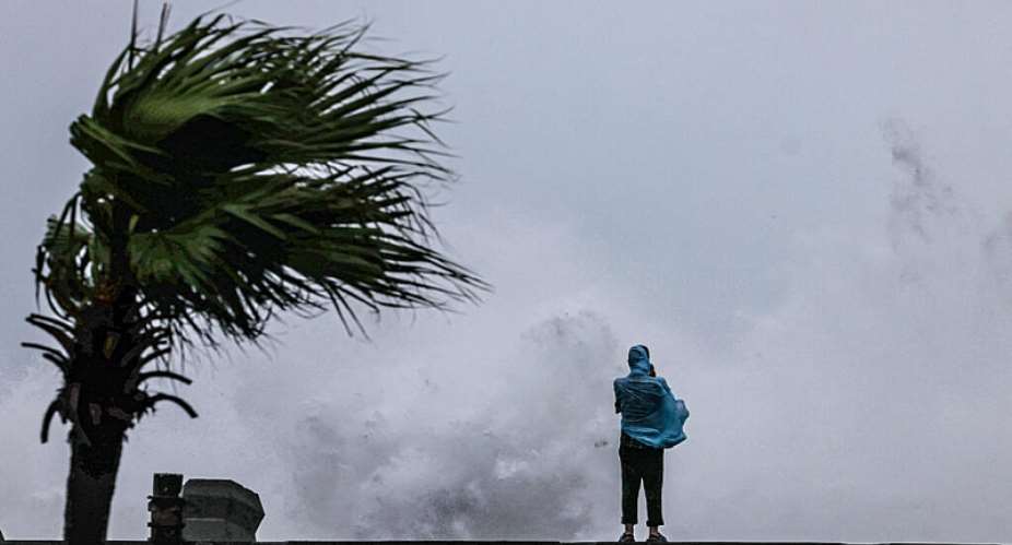 A person looks on as large waves crash against the coast as Typhoon Bavi passes off northeastern Taiwan, in Keelung on July 11, 2026. -  I-Hwa Cheng, AFP