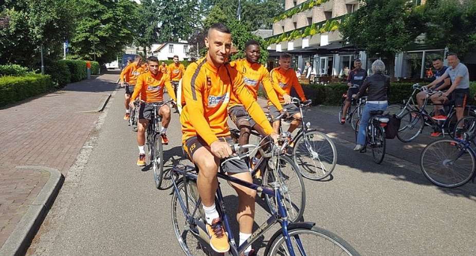Muniru Sulley jumps on a bike with Steaua Bucuresti teammates in pre-season