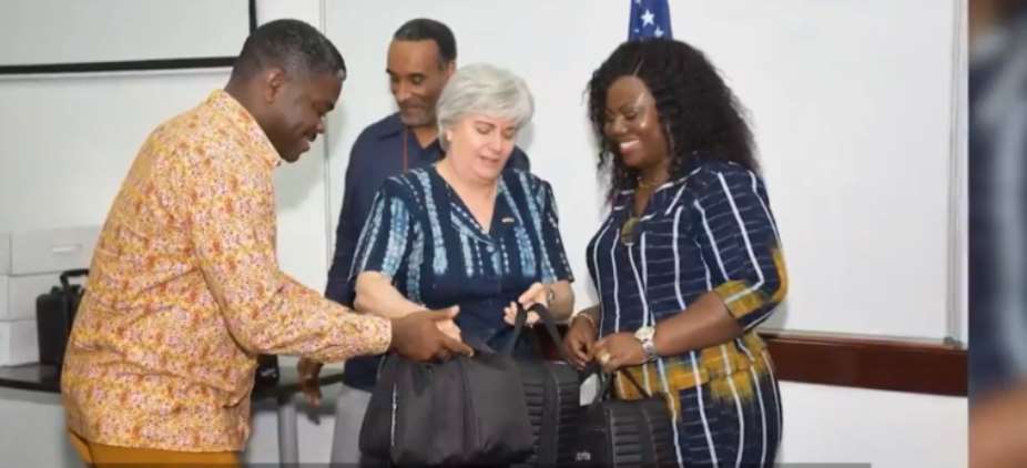 A screenshot from the YouTube channel of the U.S. Embassy in Ghana shows Ambassador Stephanie Sullivan, center, handing over Cellebrite technology to Gustav Yankson, left, director of the Ghana police cybercrime unit of the Criminal Investigation Department, and Maame Yaa Tiwaa Addo-Danquah, right, former director general of Ghana police CID. Journalists are wary that phone hacking technology could affect their safety or that of their sources