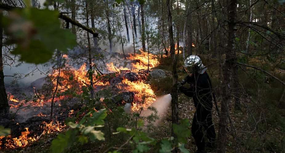 A firefighter works to extinguish flames in Noisy-sur-Ecole, in the Fontainebleau forest, 13 July 2026. -  Stphane Mahe/Reuters