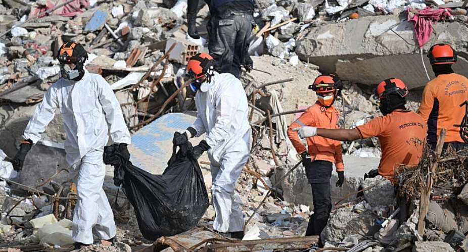 Rescue workers carry a body bag through the rubble of a collapsed building in Caraballeda, Venezuela, on 17 July 2026, following the earthquakes of 24 June. -  Juan Barreto, AFP