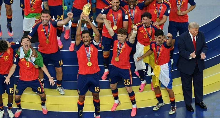 Spains midfielder #16 Rodri lifts the trophy with Spains players next to US President Donald Trump during the final ceremony after the 2026 World Cup -  ANGELA WEISS, AFP