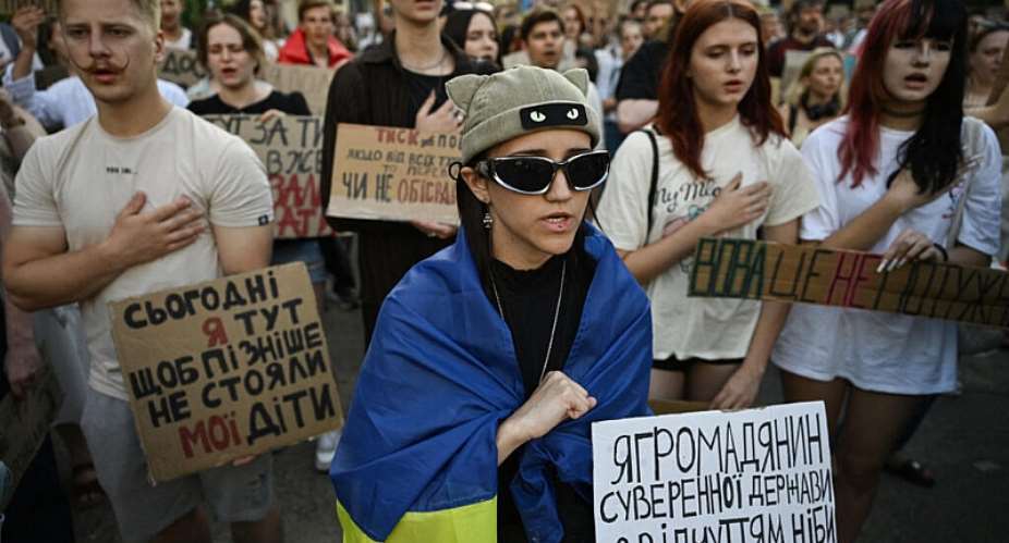 People sing the national anthem of Ukraine during a demonstration to protest against the ousting a reformist defence minister Mykhailo Fedorov and demand the dismissal of Ukraines army chief Oleksandr Syrskyi, as Ukraine President face one of the most urgent political crises of the Russian invasion, in Kyiv on 20 July 2026. - AFP - GENYA SAVILOV